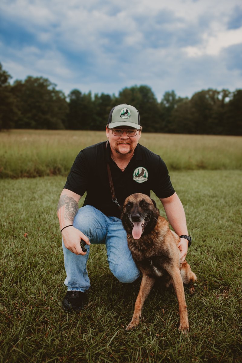 Alexander kneeling with a Belgian Malinois